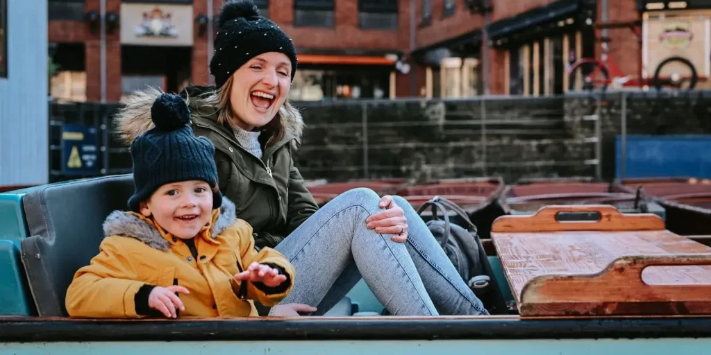 A mother and child laughing in a punting boat.