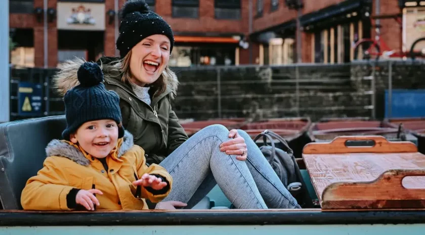 A mother and child laughing in a punting boat.