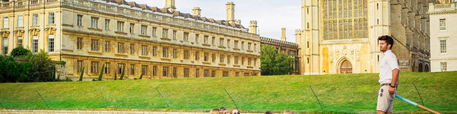 A punting boat sailing past the King's College Chapel and surrounding college buildings.