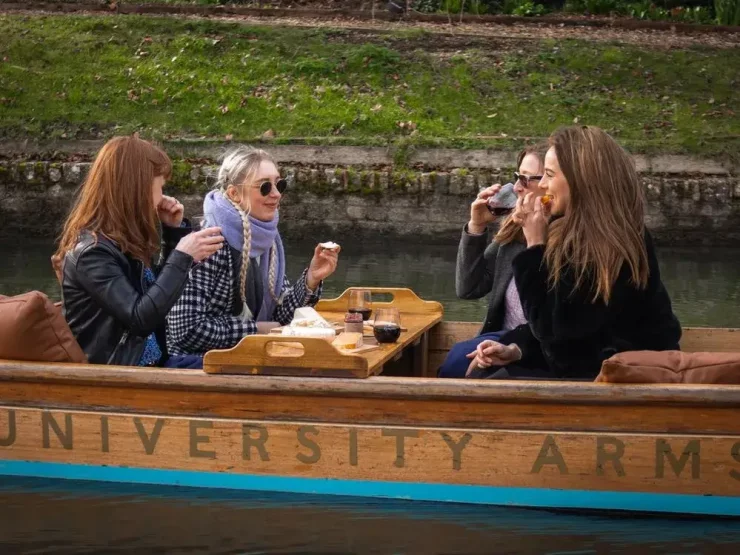4 women sitting in a punting boat having afternoon tea.