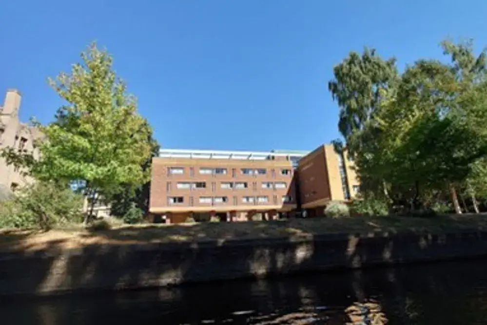 A view from the river of the Erasmus building, a squat, square, brick building.