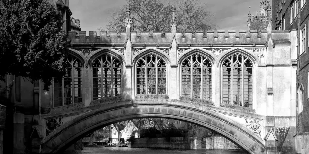A greyscale photo of the Bridge of Sighs, an ornately carved, arched stone bridge.