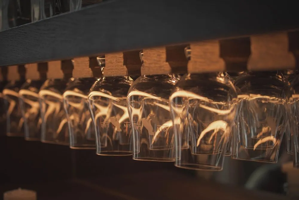 Gin glasses hung upside down in a rack.