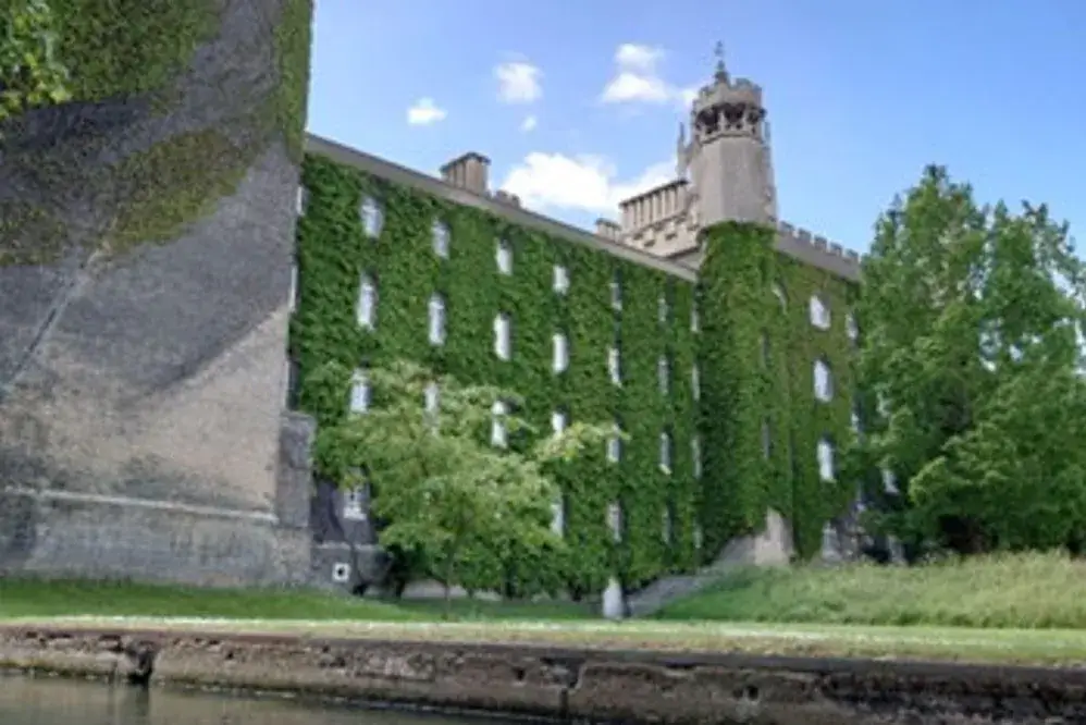 An old stone building, walls overgrown with ivy.