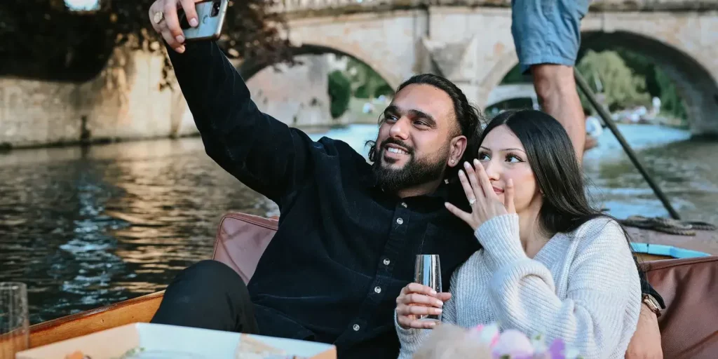 A young couple taking a selfie on a punting boat.