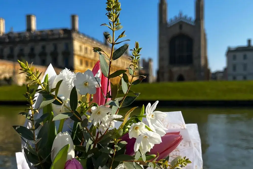 A close-up of a bouquet of flowers, with King's College Chapel out of focus in the background.